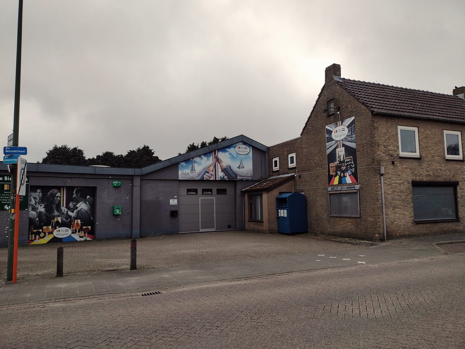 A beer store and parking lot with a mural showing Dutch and Belgian beers meeting