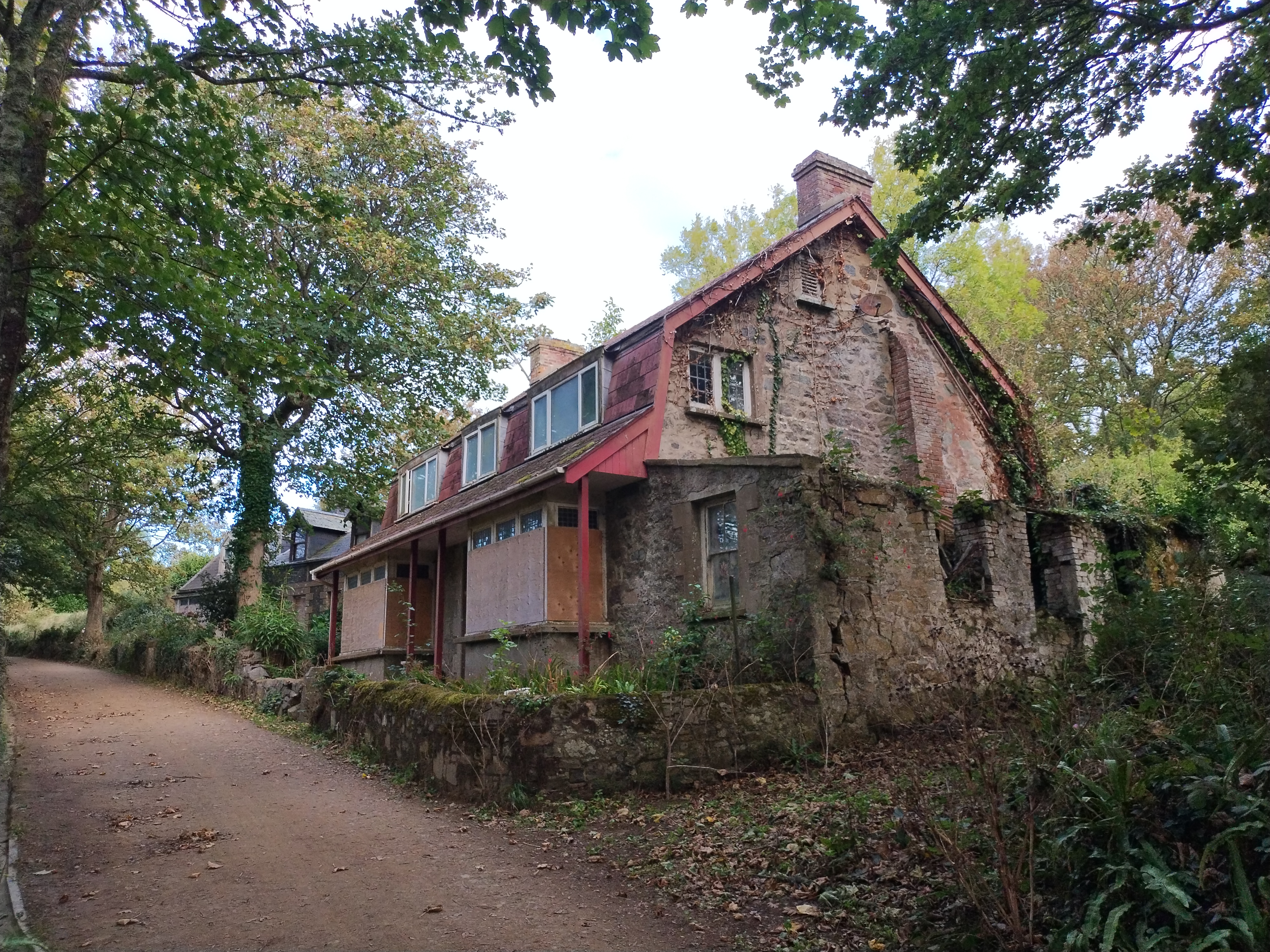 A nice house with mostly boarded-up windows and some broken glass